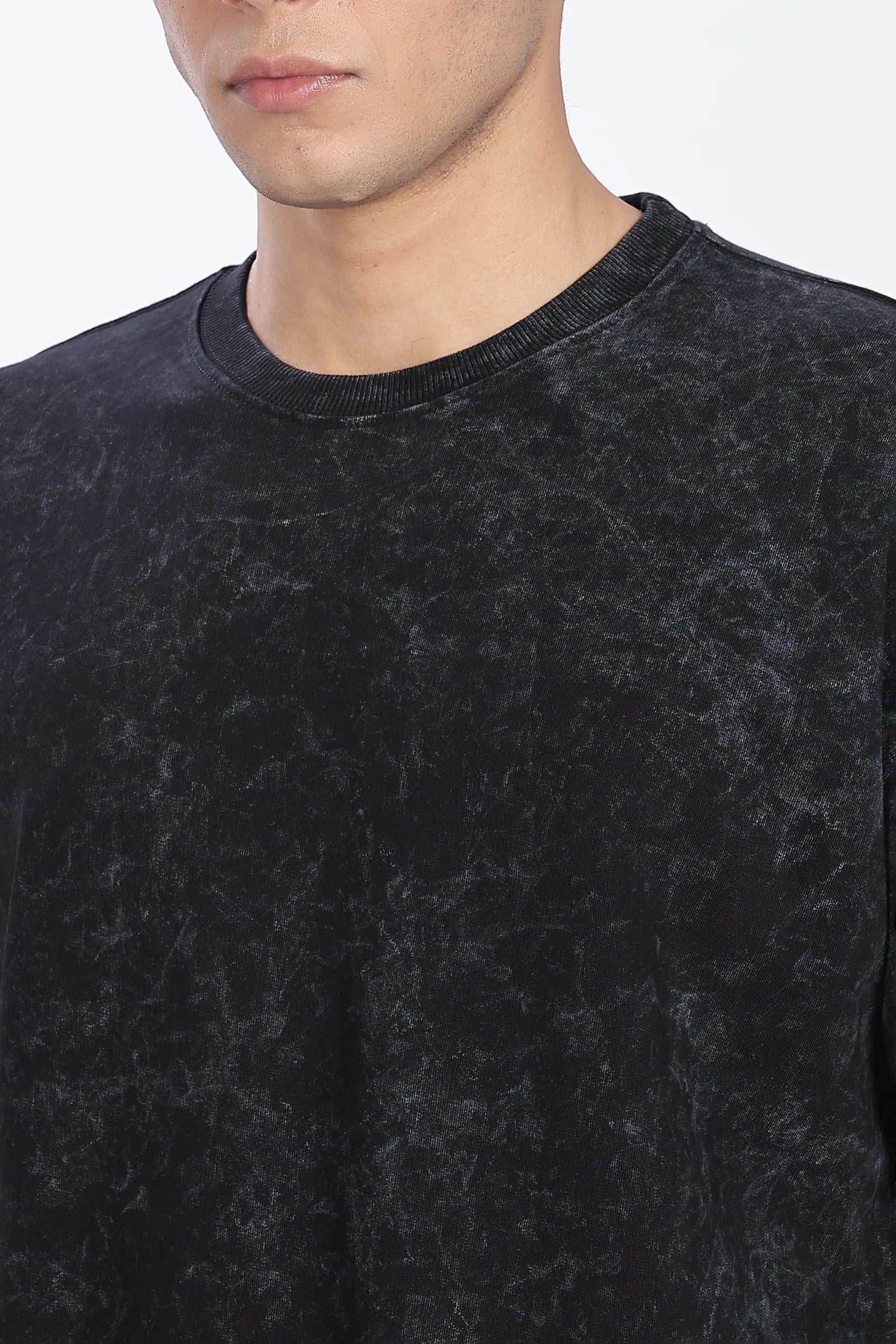 Close-up of a person wearing a black textured sweater against a white background