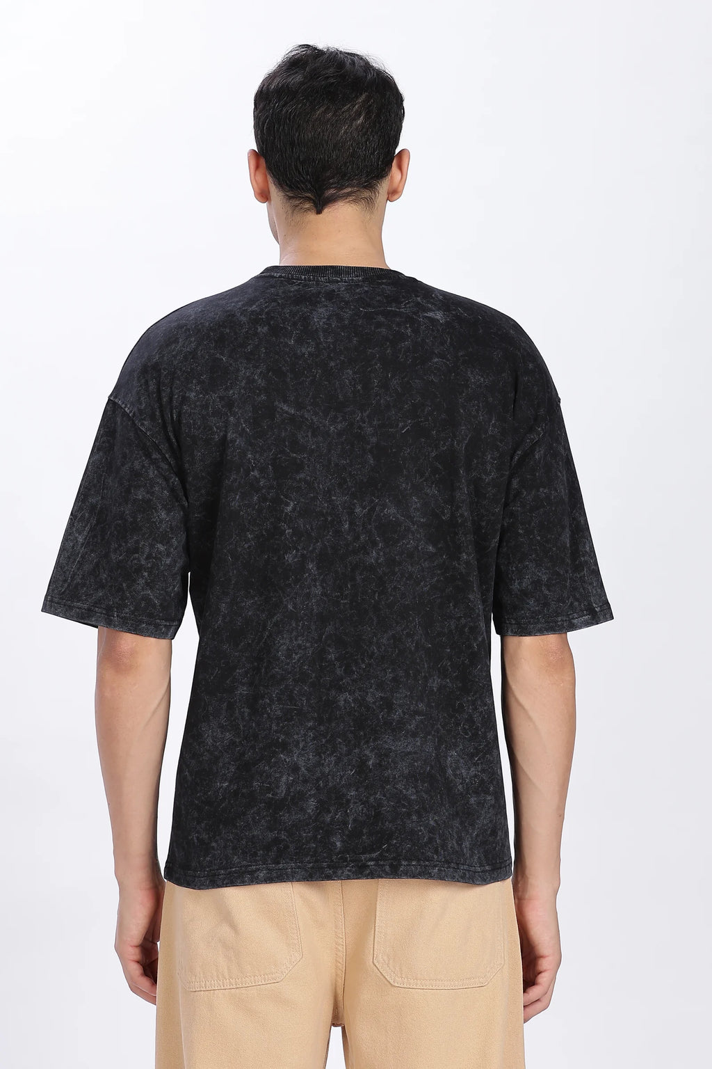 Person wearing a black patterned t-shirt on a white background