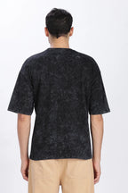 Person wearing a black patterned t-shirt on a white background