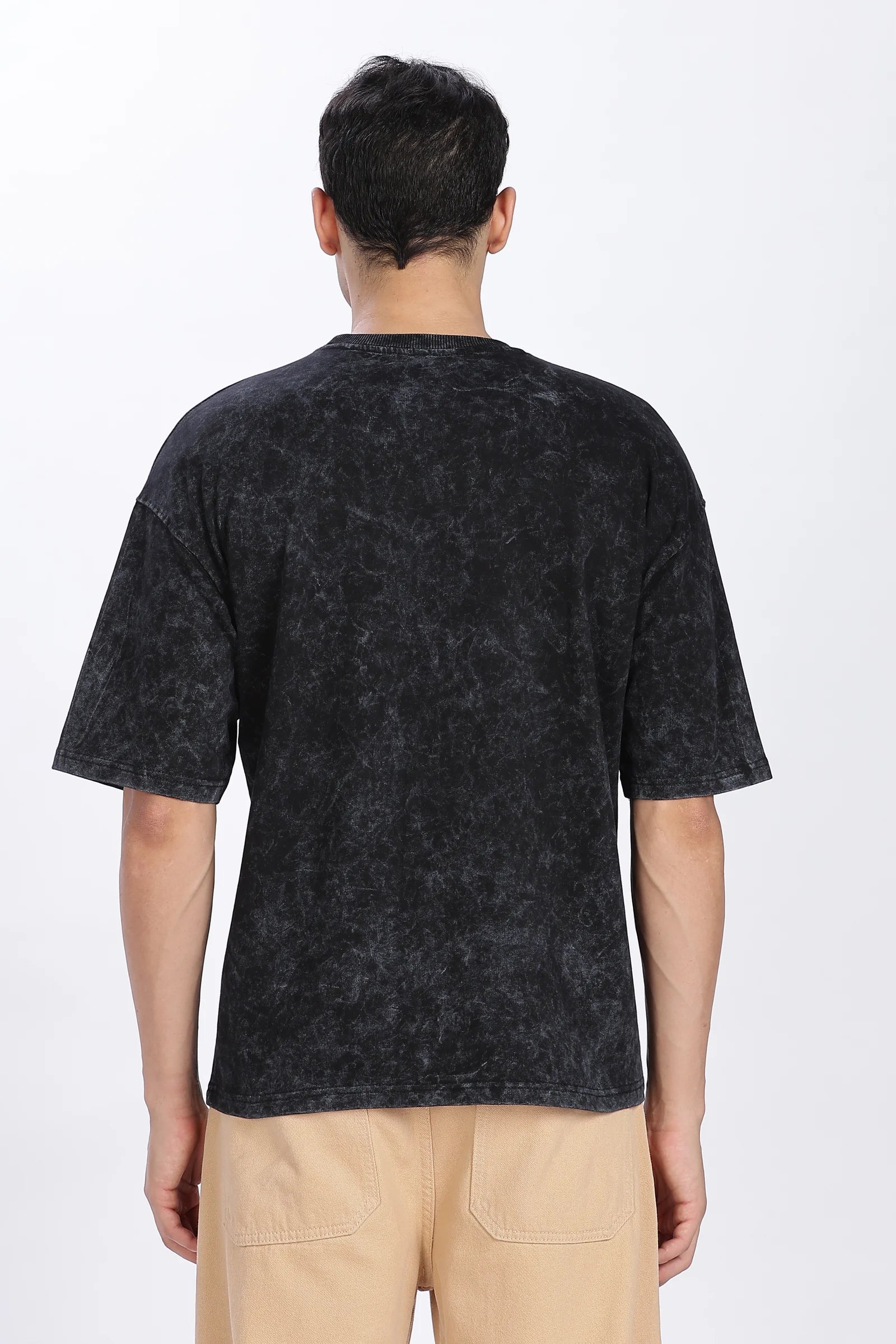 Person wearing a black patterned t-shirt on a white background
