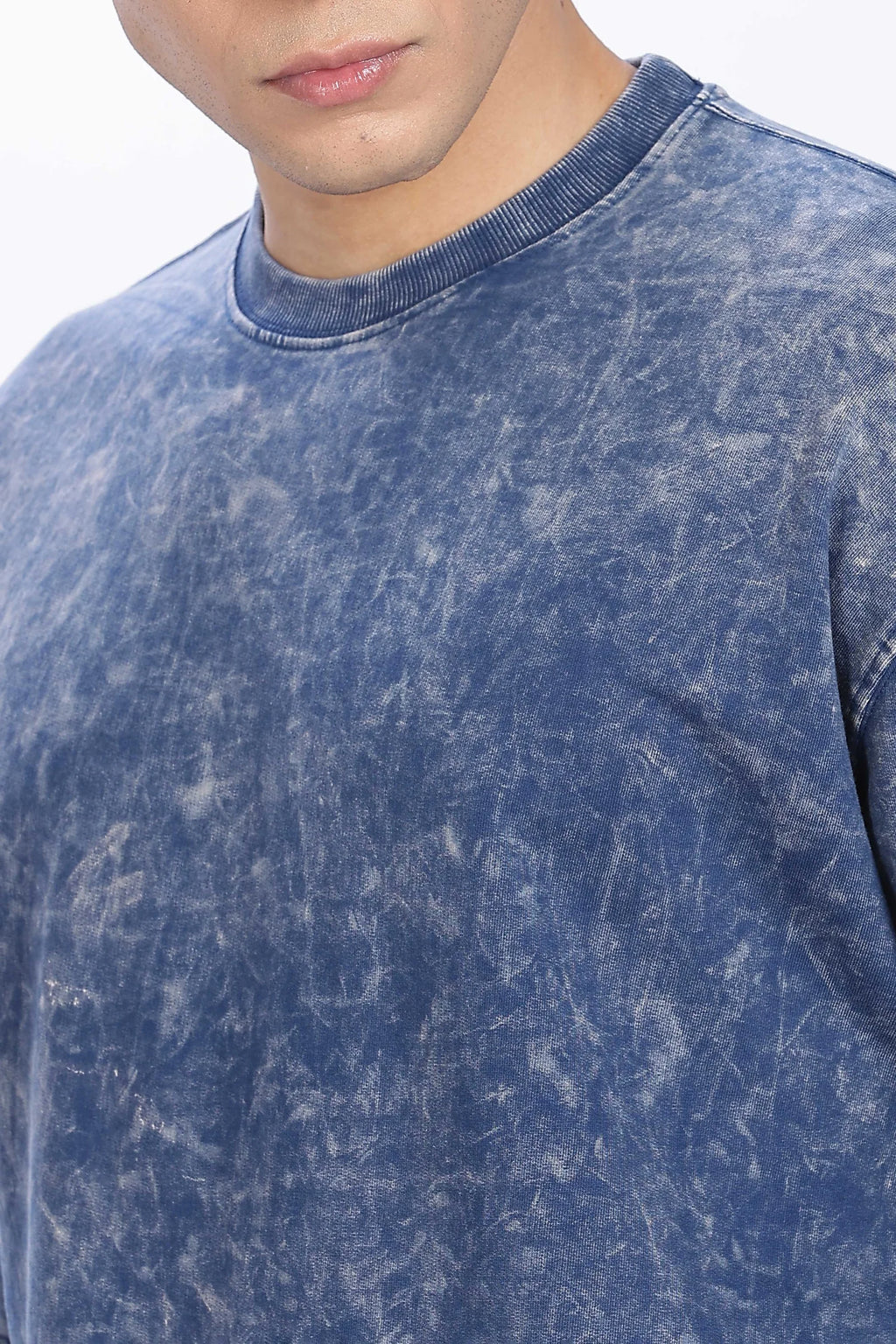 Close-up of a person wearing a blue acid-wash shirt.