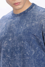 Close-up of a person wearing a blue acid-wash shirt.