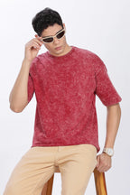 Man wearing a red t-shirt and beige pants with sunglasses on a white background