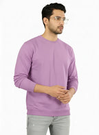Man wearing a purple sweatshirt and gray pants on a white background