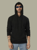 Person wearing a black hoodie and sunglasses on a plain background
