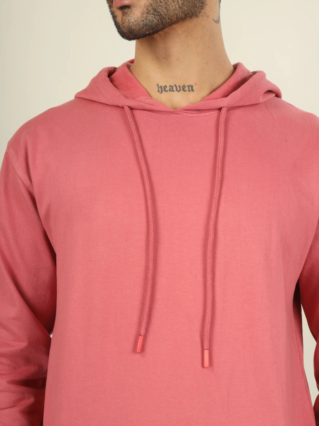 Person wearing a pink hoodie with a neutral background