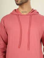 Person wearing a pink hoodie with a neutral background
