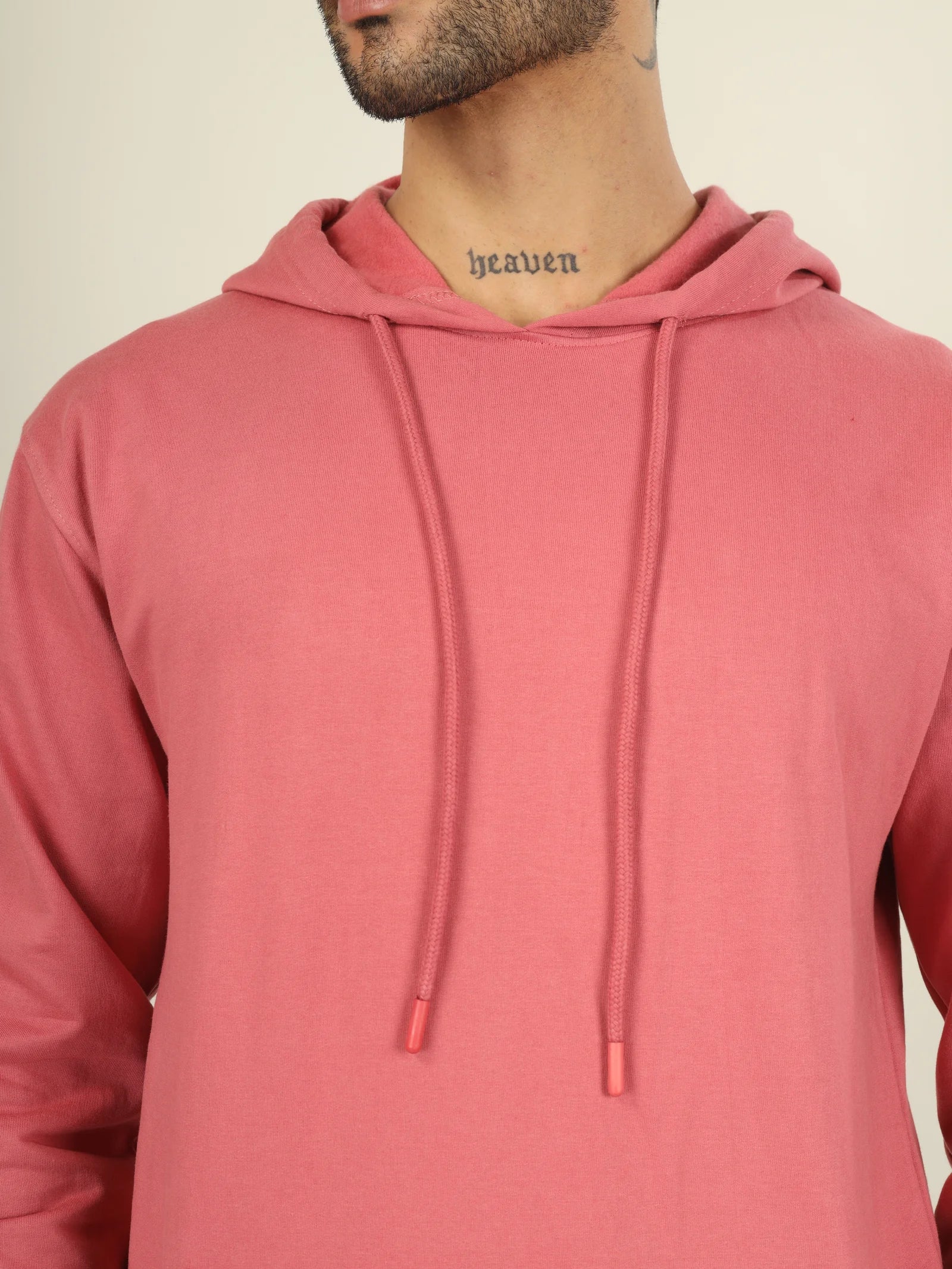 Person wearing a pink hoodie with a neutral background