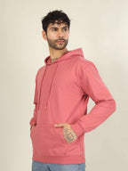 Man wearing a pink hoodie against a beige background