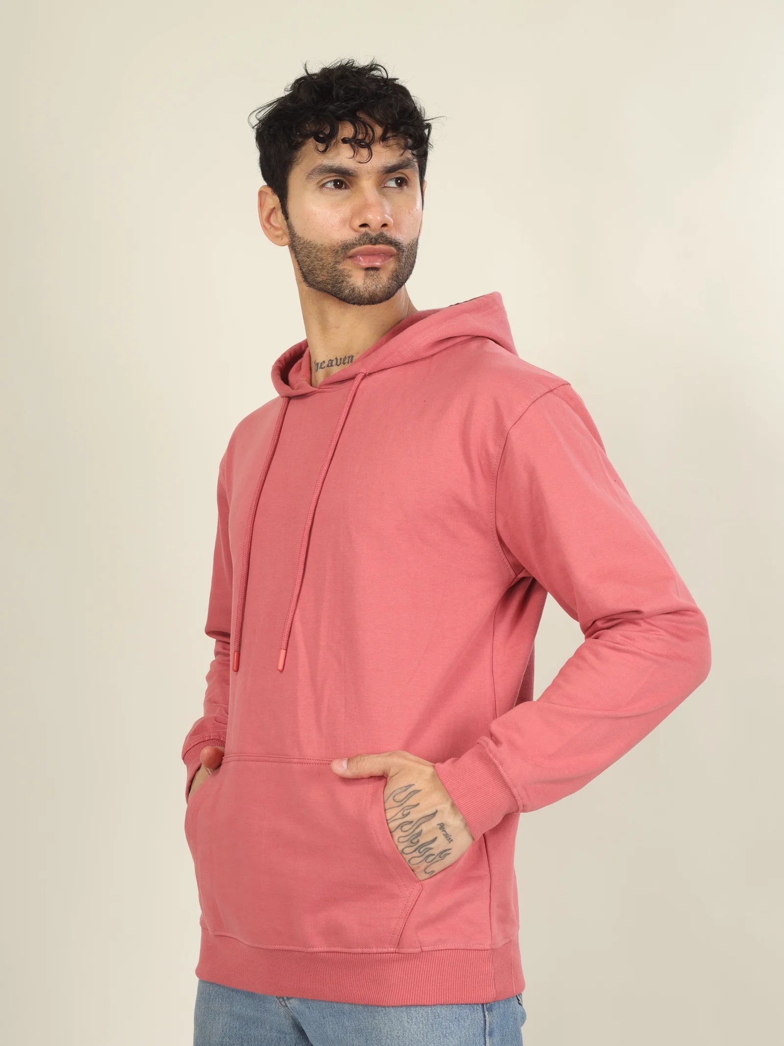 Man wearing a pink hoodie against a beige background