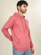 Man wearing a pink hoodie against a plain background