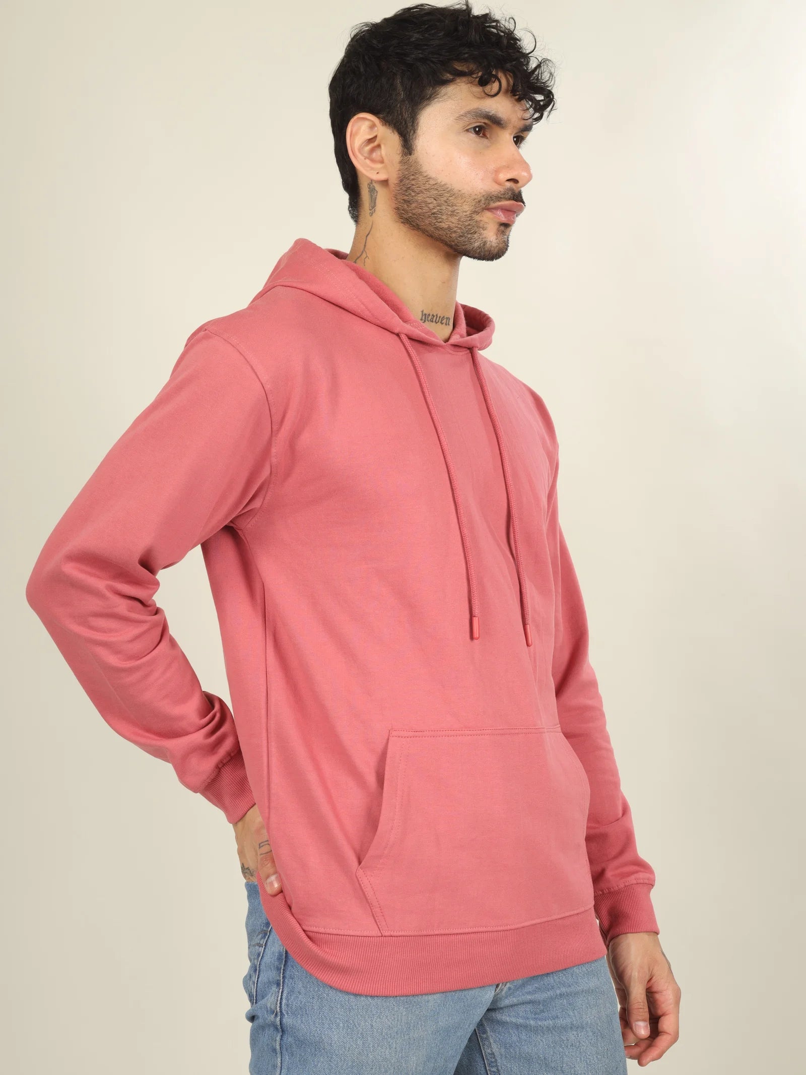Man wearing a pink hoodie against a plain background