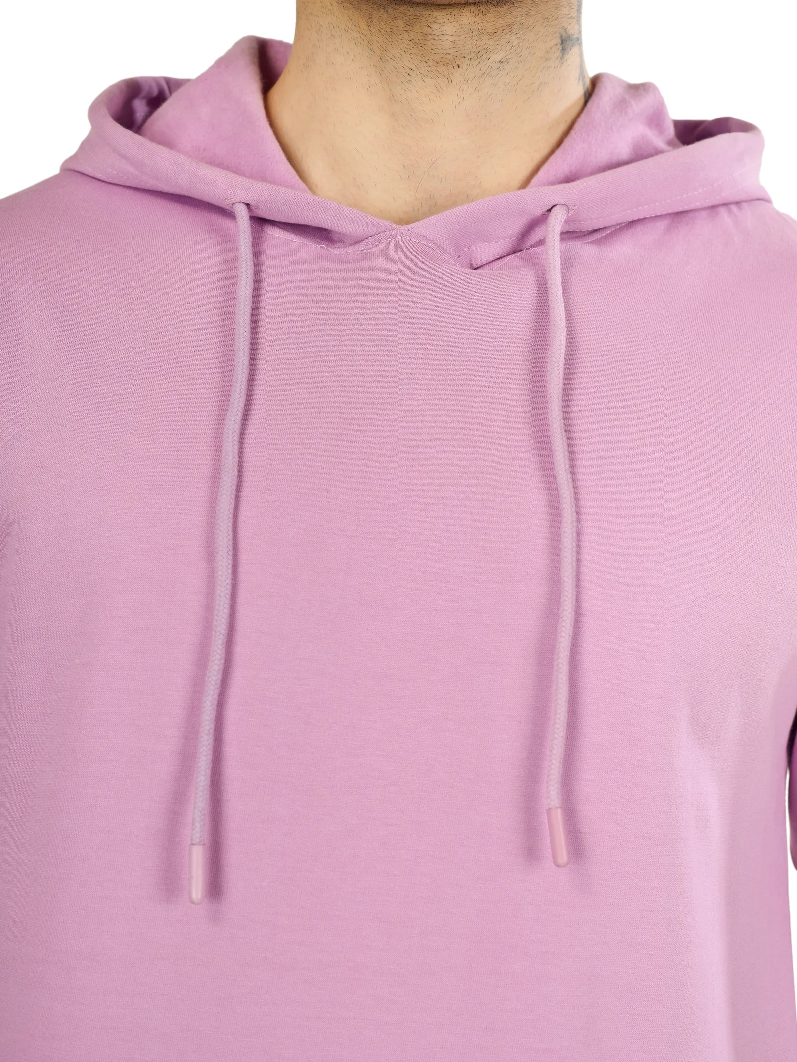 Close-up of a person wearing a light purple hoodie with a plain background