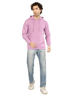 Man wearing a pink hoodie and light blue jeans on a white background