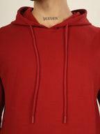 Red hoodie worn by a person with 'heaven' tattoo on neck against a neutral background