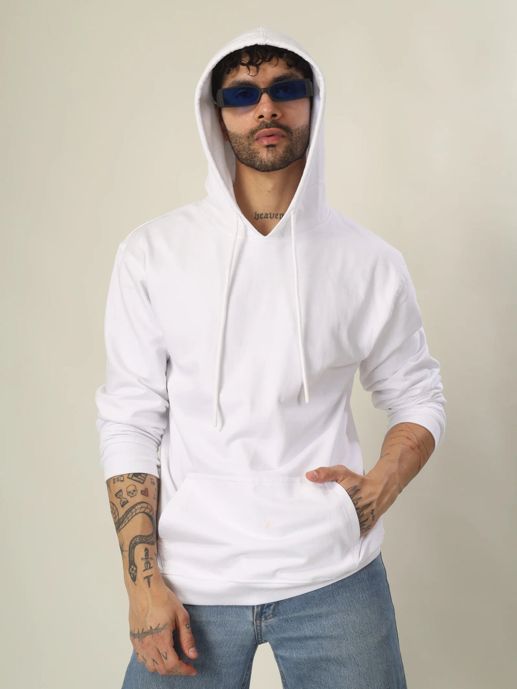 Man wearing a white hoodie and sunglasses against a plain background