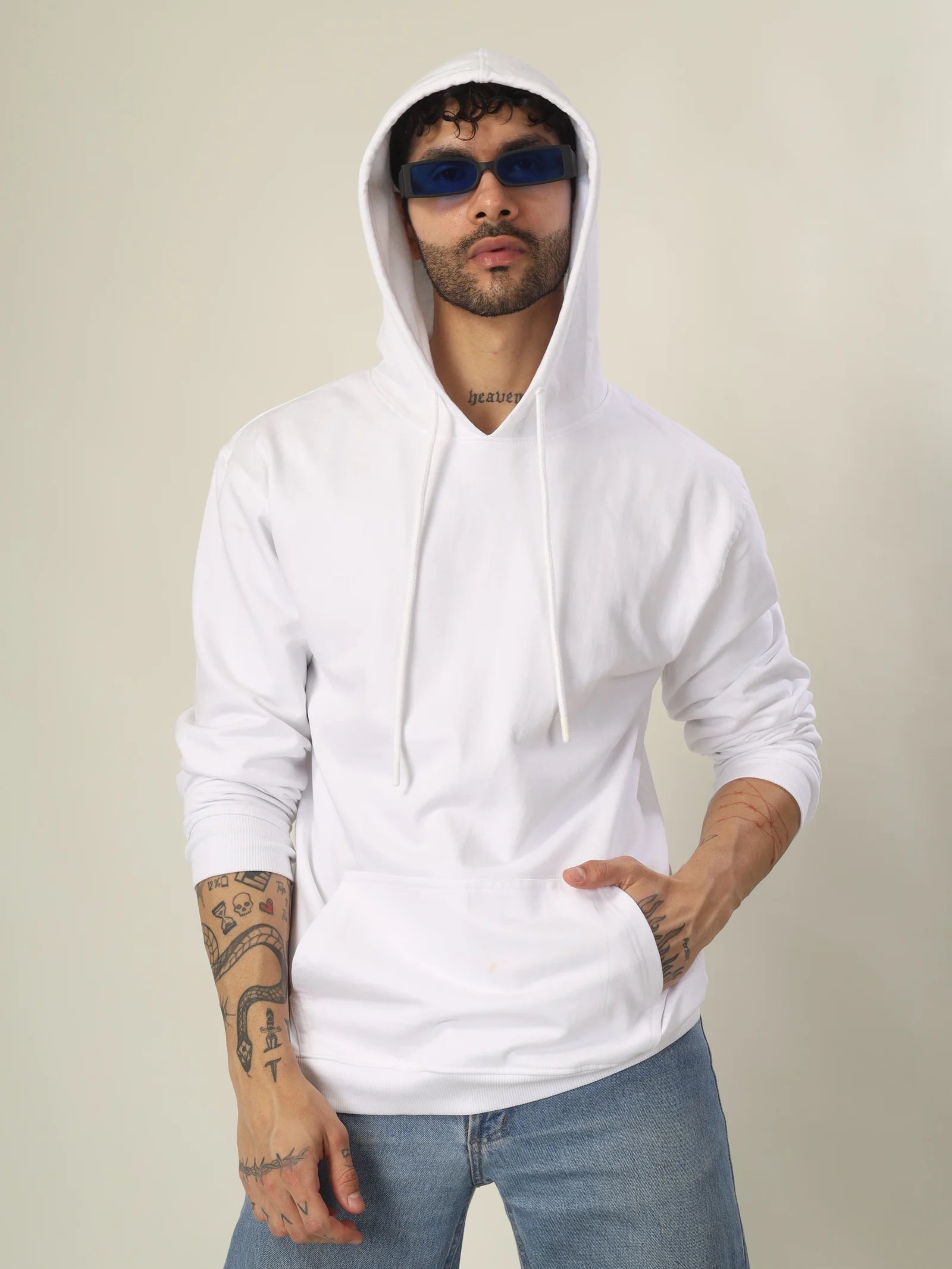 Man wearing a white hoodie and sunglasses against a plain background