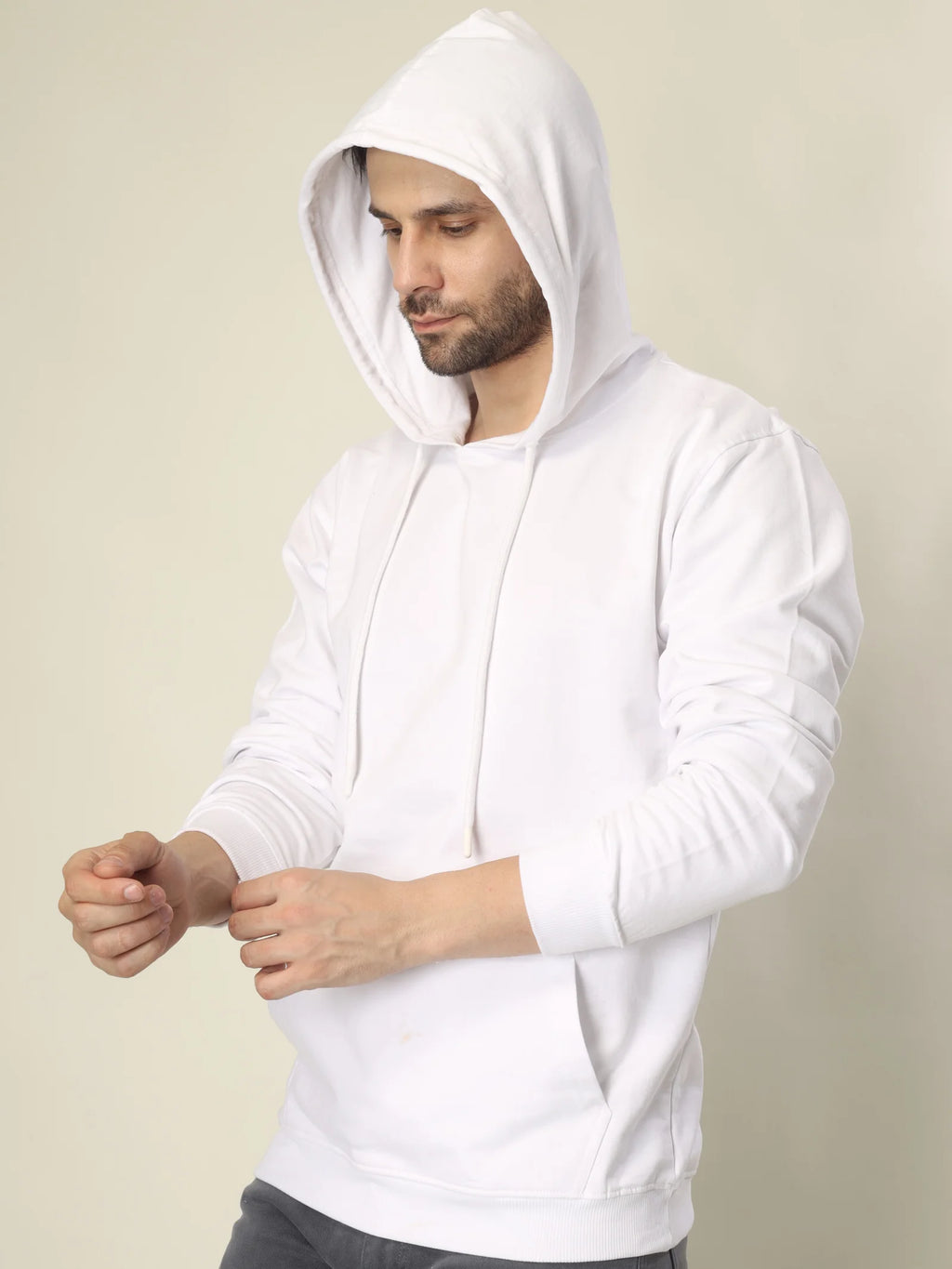 Man wearing a white hoodie against a beige background