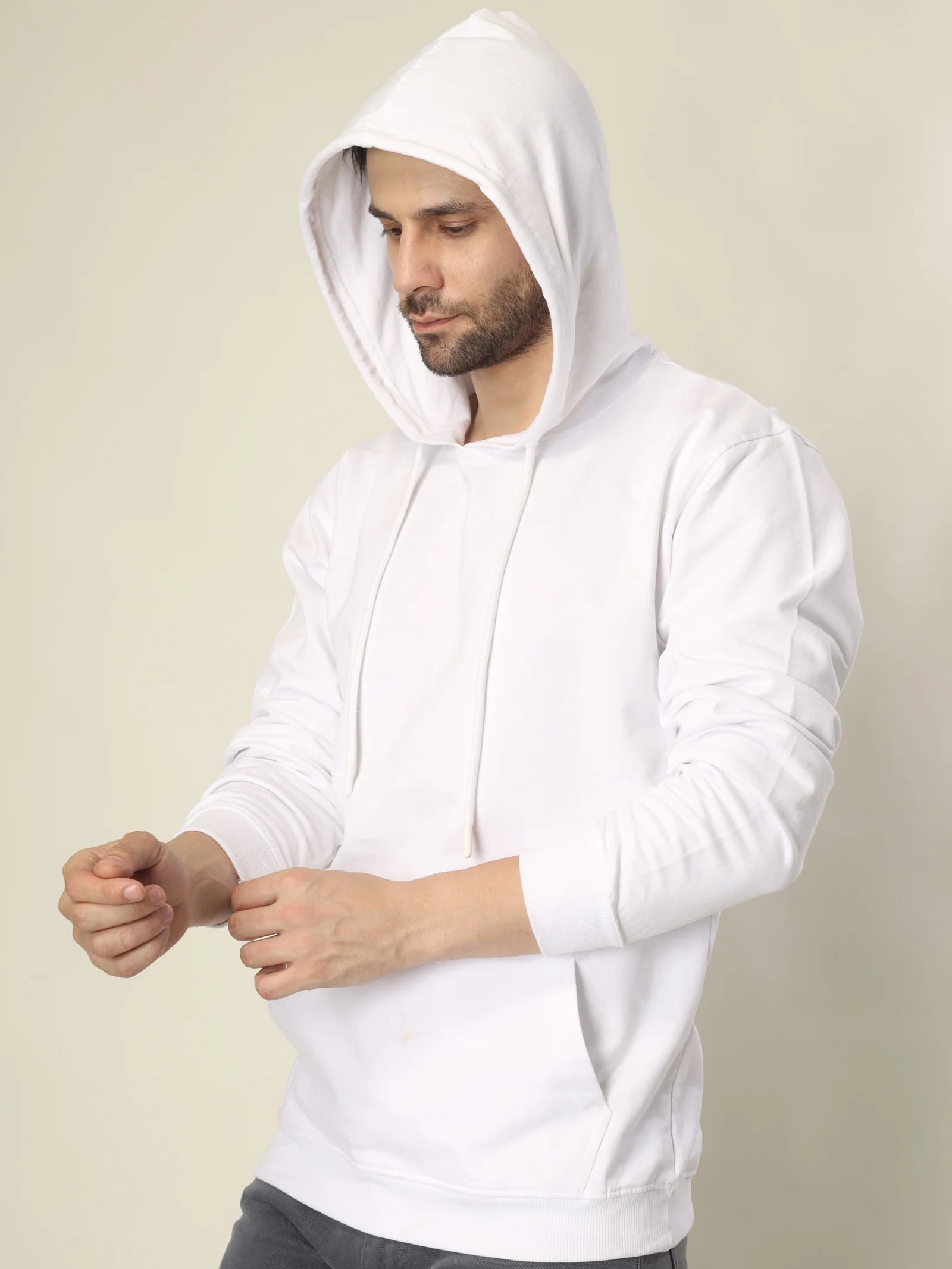 Man wearing a white hoodie against a beige background