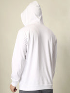 White hoodie worn by a person on a beige background