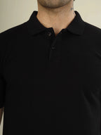 Black polo shirt worn by a person against a neutral background