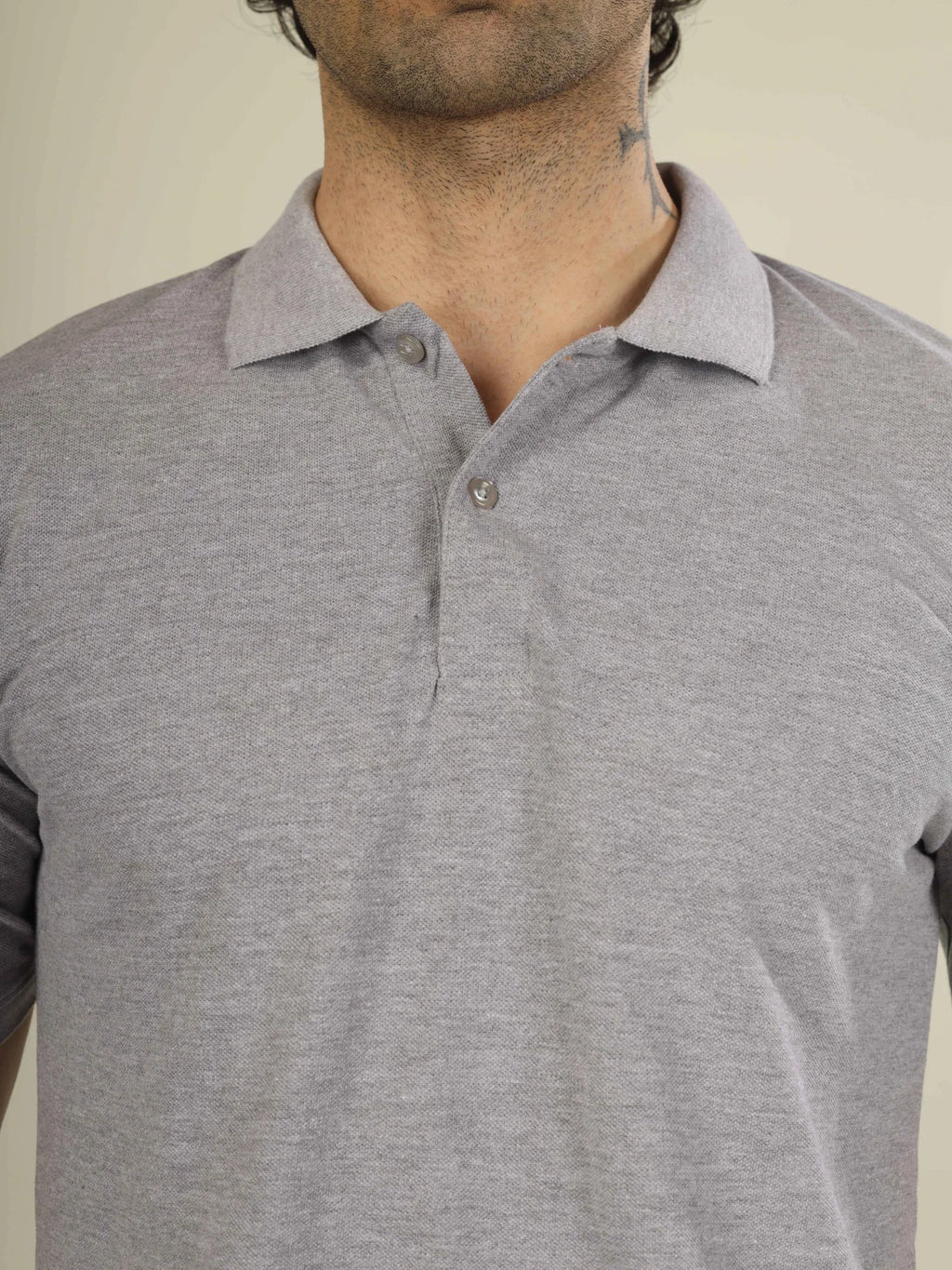 Gray polo shirt worn by a person on a plain background