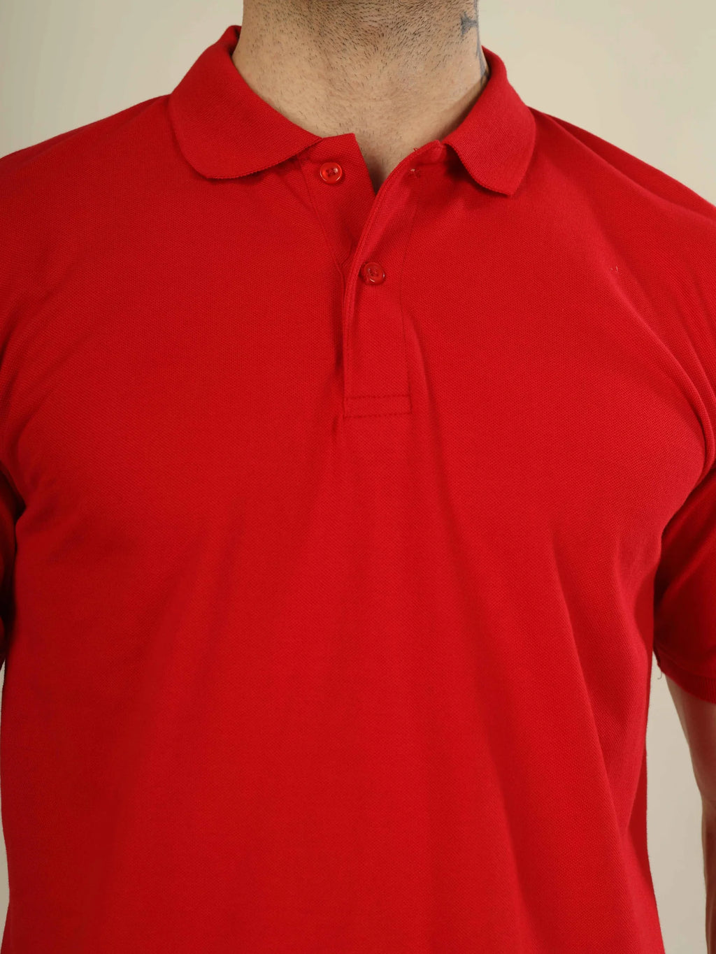 Red polo shirt on a mannequin against a plain background