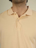 Beige polo shirt worn by a person on a neutral background