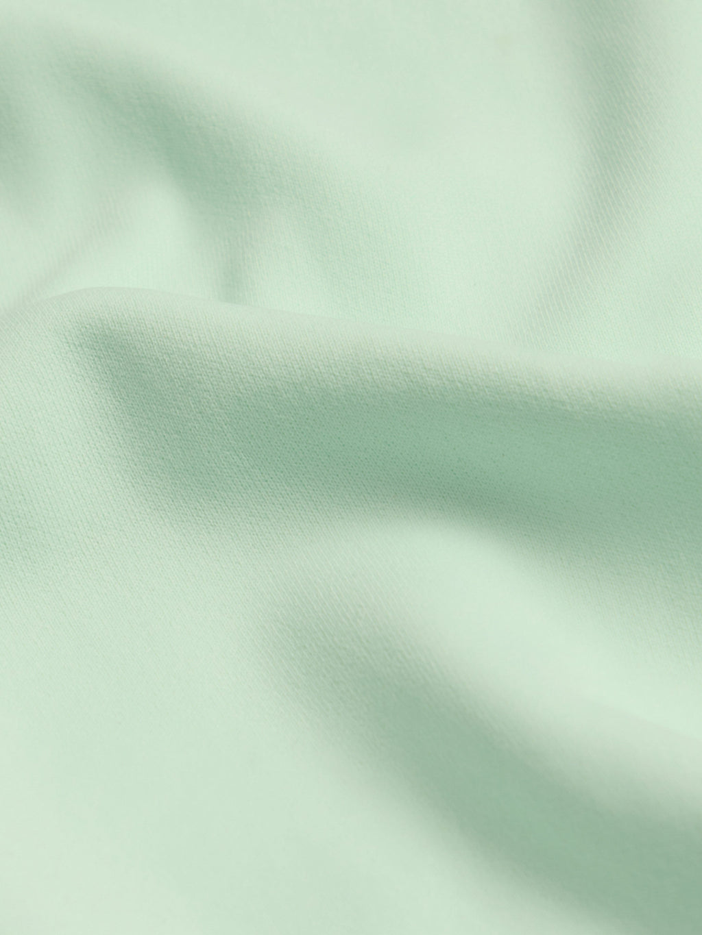 Close-up of light green fabric with folds