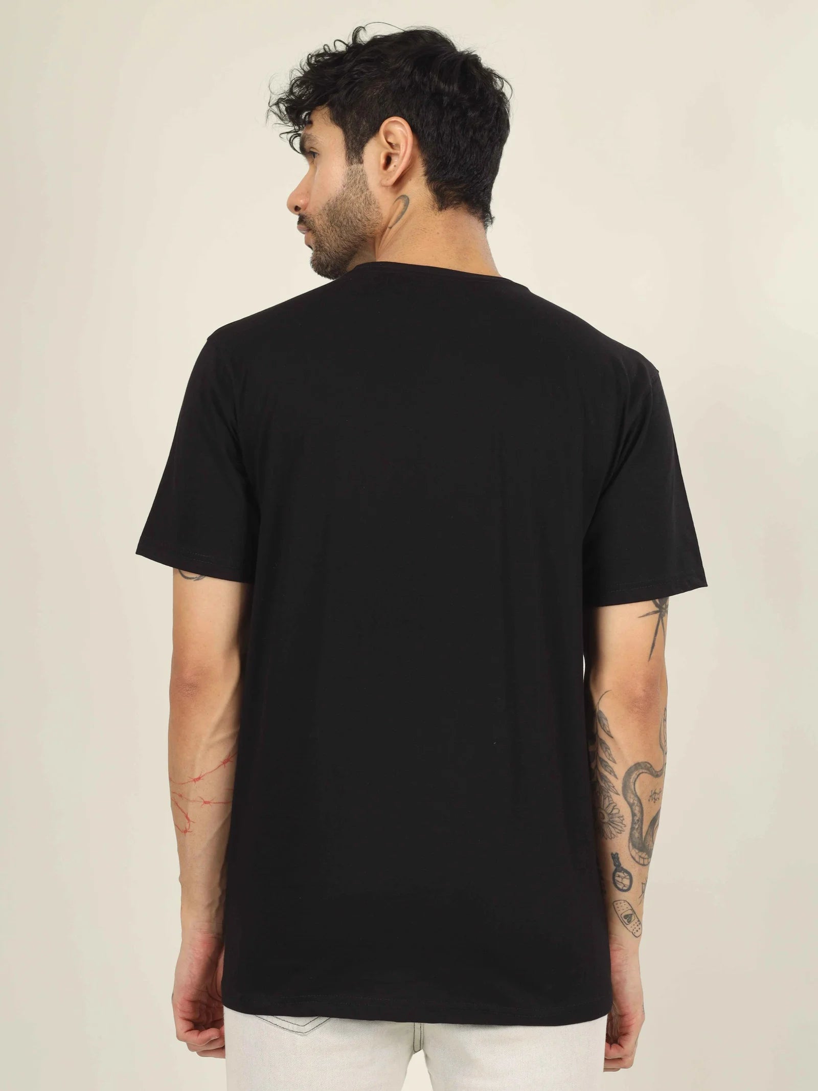 Man wearing a black t-shirt on a beige background