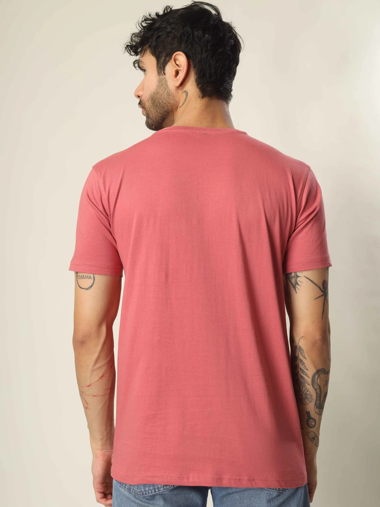 Man wearing a red t-shirt against a beige background