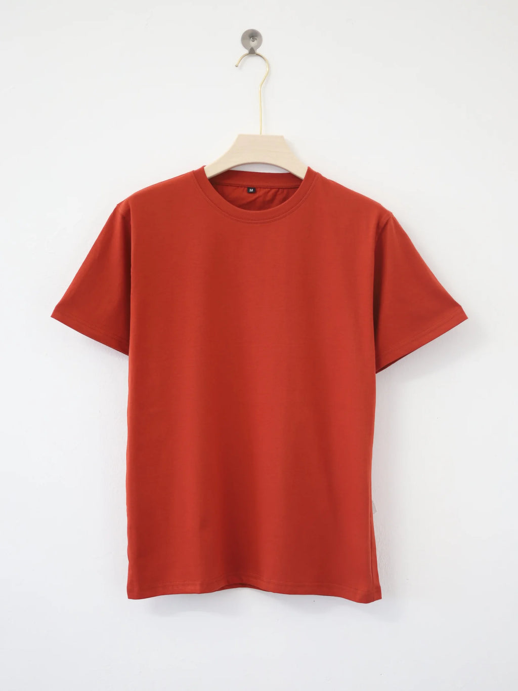 Red t-shirt on a hanger against a white background