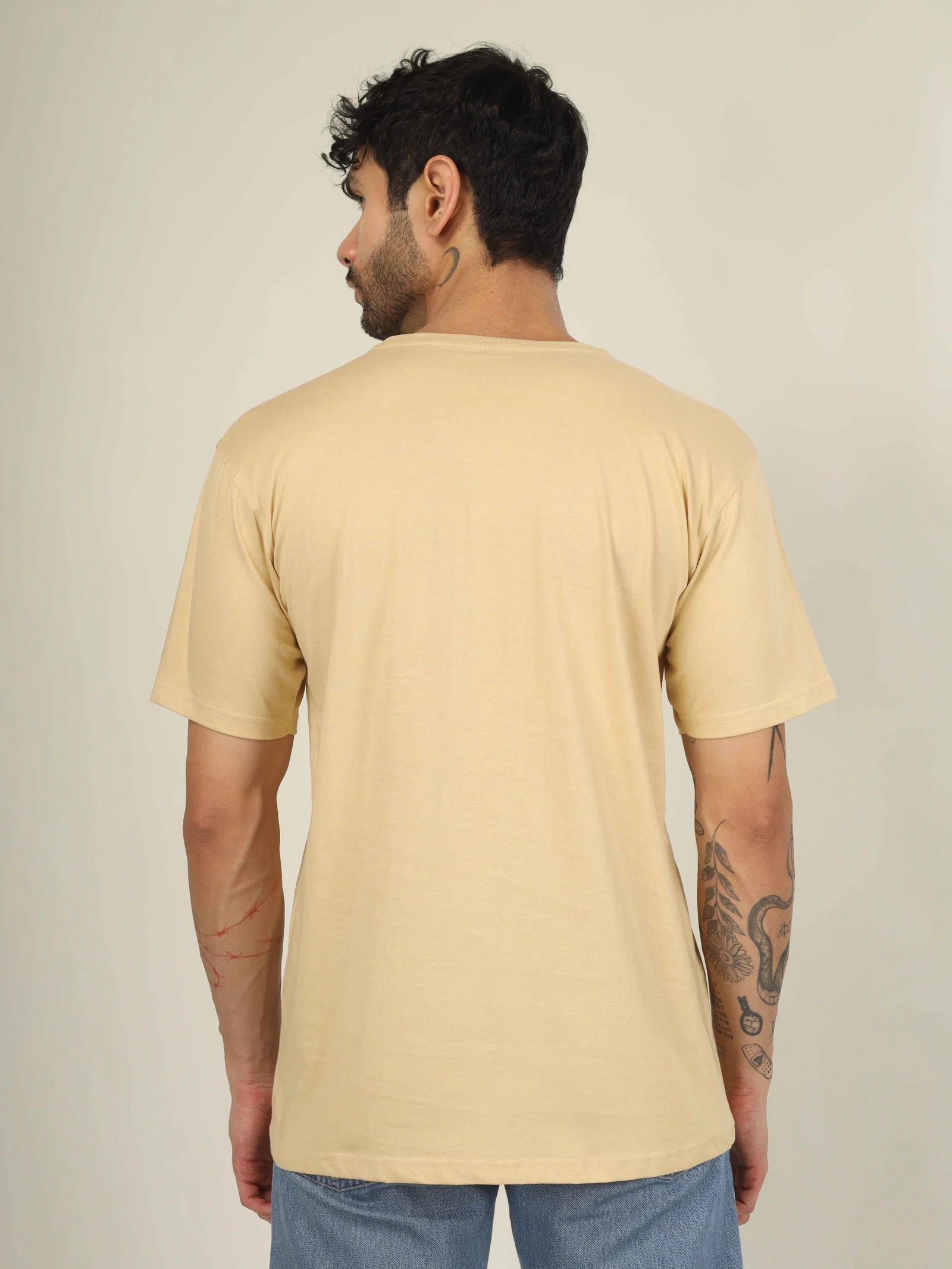 Man wearing a beige t-shirt against a plain background