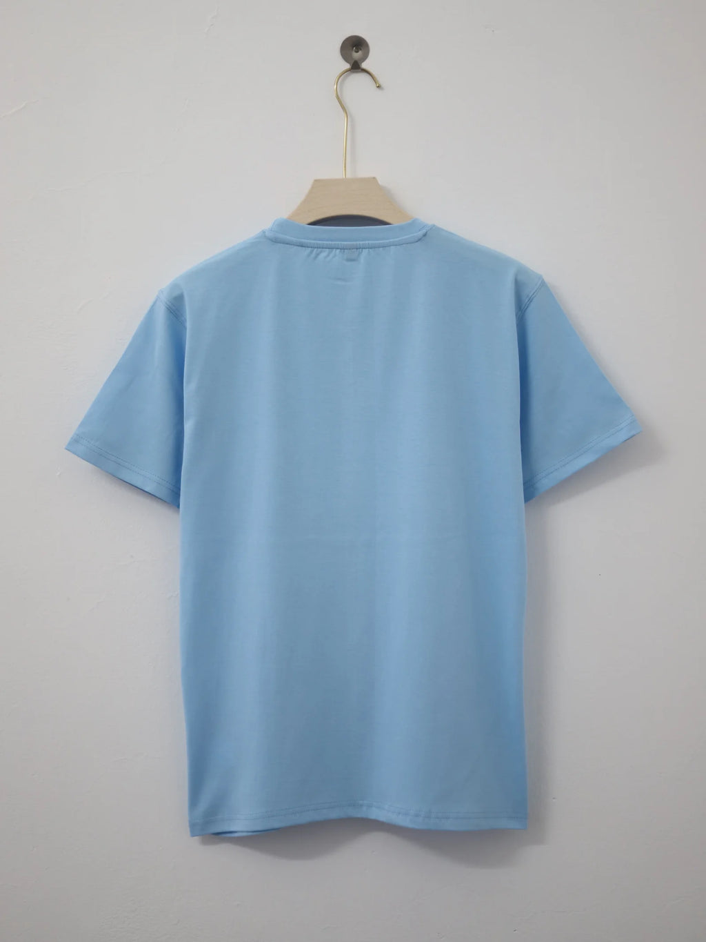 Light blue t-shirt on a hanger against a plain background