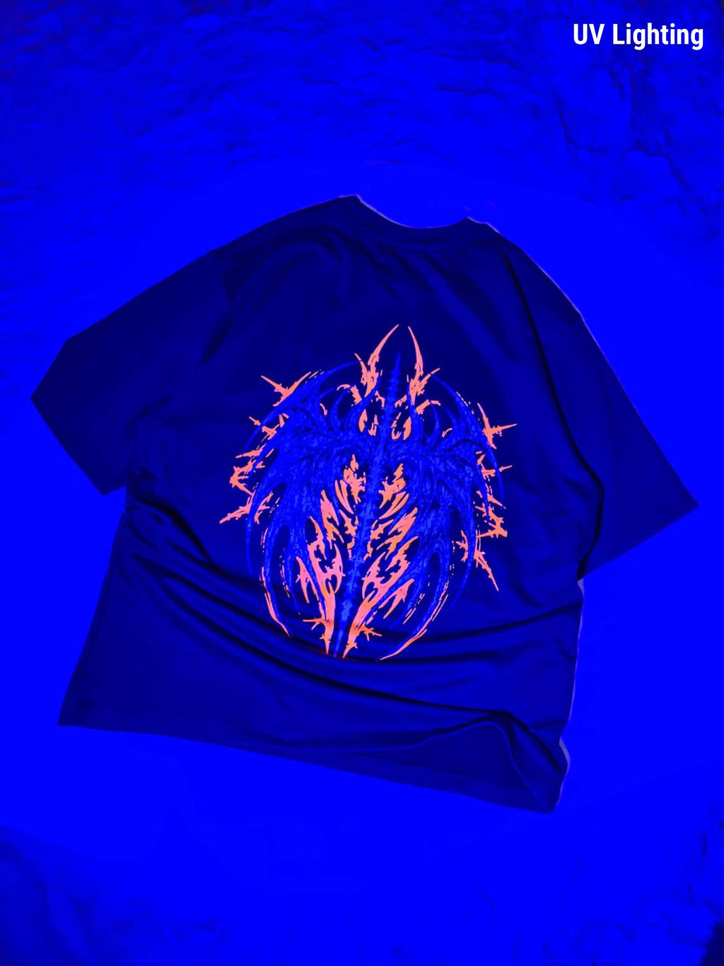 A black t-shirt displayed under UV lighting, showing a glowing neon orange and blue graphic on the front. The text 'UV Lighting' is visible in the top right corner.
