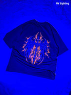 A black t-shirt displayed under UV lighting, showing a glowing neon orange and blue graphic on the front. The text 'UV Lighting' is visible in the top right corner.