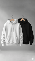 White and black hoodies on hangers against a gray background